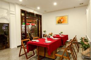 a dining room with a red table and chairs at Royal Hotel Ha noi in Hanoi