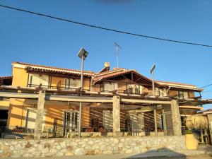 a large building with a stone wall at 9 Musses Studios in Skala Mistegnon