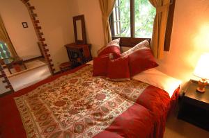 a bedroom with a large bed with red pillows at Pension Belnina in Hakuba