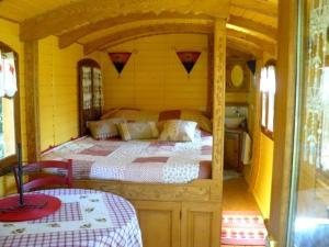 a bedroom in a bus with a bed in it at La Clé des Roulottes in Pluvigner