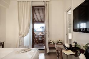 a room with a bed, a table, a mirror and a window at Hotel Italia in Siena