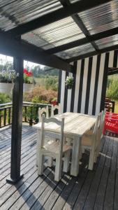 un tavolo e una panca in legno su una terrazza di legno di Woodcutters Guest House a Haenertsburg