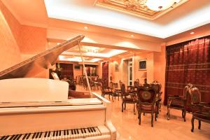 un ristorante con pianoforte, tavoli e sedie di White House Hotel a Ulaanbaatar
