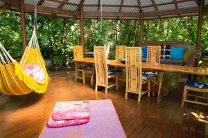 a porch with a hammock and a table and chairs at Wildwood in Cape Tribulation