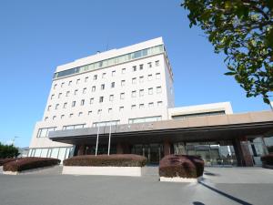 Un grand bâtiment blanc avec de nombreuses fenêtres dans l'établissement Hotel Satsukien, à Kanoya