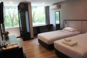 a hotel room with two beds and a desk at YWCA Hotel Bangkok in Bangkok