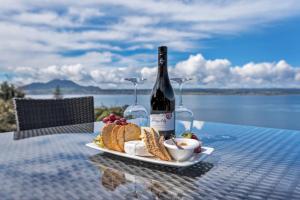 uma garrafa de vinho e um prato de comida numa mesa em Serenity On Wakeman em Taupo