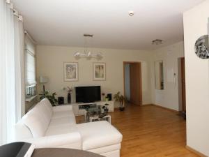 a living room with a white couch and a tv at Apartments Panevezys in Panevėžys