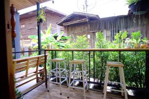 a balcony with two stools and a railing at Nap Corner hostel in Phitsanulok