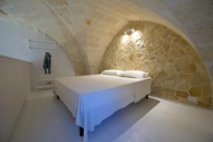 a bedroom with a bed in a stone wall at Casa Bova in Mesagne