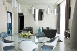 a living room with a glass table and chairs at JR Hotels Bari Grande Albergo delle Nazioni in Bari