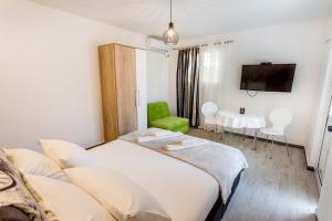 a bedroom with a bed and a table and a tv at Apartments Batricevic in Herceg-Novi