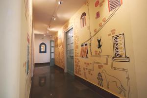a hallway with a wall with drawings on it at Jaipur Jantar Hostel in Jaipur