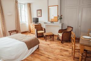 1 dormitorio con 1 cama, mesa y sillas en Appart Hotel Charles Sander en Salins-les-Bains