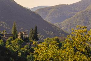 uma casa num vale com montanhas ao fundo em Wild Valley Hostel - Villa Edera em Auressio