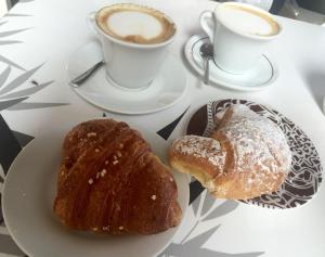 a table with two plates of pastries and a cup of coffee at Echi del Mare in La Spezia