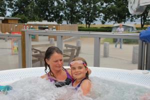 two young girls sitting in a hot tub at First Camp Holbæk Fjord in Holbæk