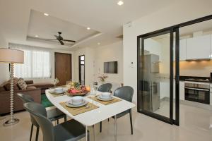 a dining room and living room with a white table and chairs at Laguna Townhome Bangtao in Bang Tao Beach