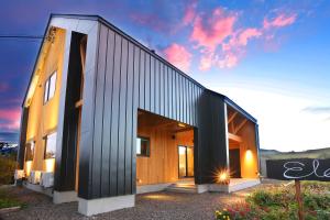 a house with a black and wooden facade at Element in Nakafurano