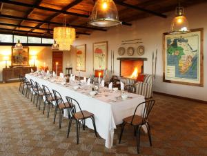a long table with chairs in a room at Fugitives Drift Lodge in Rorkeʼs Drift
