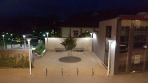 a building with a tree in a courtyard at night at Gästehaus Samuel in Völklingen