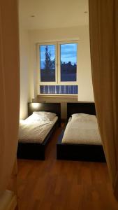 2 Betten in einem Zimmer mit 2 Fenstern in der Unterkunft Gästehaus Samuel in Völklingen