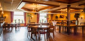 ein Restaurant mit Holztischen und Stühlen in einem Raum in der Unterkunft Hotel Restaurant Het Roode Hert in Dalfsen