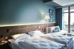 Postel nebo postele na pokoji v ubytování Das Sonnreich - Thermenhotel Loipersdorf