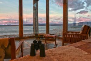 a room with a view of the ocean from a house at Hotel Simple Patagonia in Puerto Natales