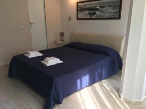 Un dormitorio con una cama azul con dos toallas encima. en La Casa di Matteino, en Génova