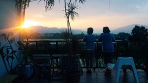 dos personas de pie en un balcón viendo la puesta de sol en Puli Islet Inn en Puli