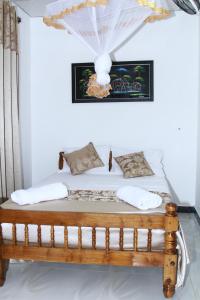 a bed with white sheets and pillows in a room at White Tusk Udawalawe in Udawalawe