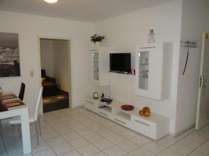 a white living room with a tv and a table at Apartment Gerda in Dieburg