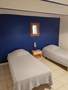 two beds in a room with a blue wall at Mas de Guinot in Villeneuve