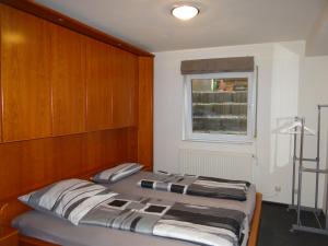 ein Schlafzimmer mit einem Bett mit hölzernem Kopfteil und einem Fenster in der Unterkunft Apartment Gerda in Dieburg