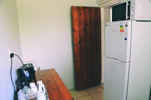 a kitchen with a table and a white refrigerator at House Forget Me Not in Bredasdorp