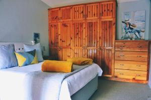 a bedroom with a large wooden cabinet and a bed at House Forget Me Not in Bredasdorp