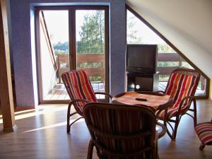 a room with a table and chairs and a television at DW Złote Kłosy in Wrony