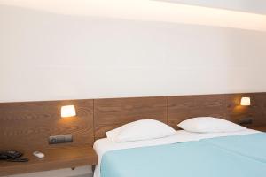 ein Schlafzimmer mit zwei Betten und einem hölzernen Kopfteil in der Unterkunft Long Beach Kokkari Samos in Kokkari