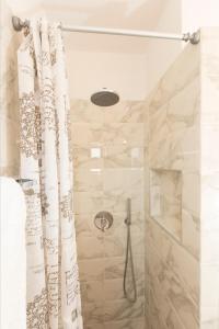 ein Badezimmer mit Dusche und Duschvorhang in der Unterkunft Long Beach Kokkari Samos in Kokkari