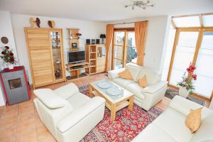 a living room with white furniture and a tv at Ferienhaus Angermeier in Oberstdorf