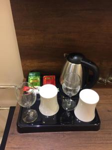 a tea pot and three glasses on a tray at Golden Square in Khamis Mushayt
