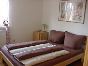 ein braunes Sofa mit Kissen darauf im Zimmer in der Unterkunft Gästehaus Eichwald in Neuenbürg