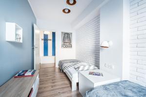 1 dormitorio con 2 camas y pared de ladrillo blanco en Stylish Apartment Posnania City Center en Poznan
