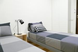 ein Schlafzimmer mit 2 Betten neben einer Lampe in der Unterkunft Luxury Manfredi Apartment Salerno in Salerno