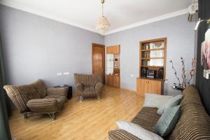 una sala de estar con un sofá y dos sillas en Eden, en Tiflis