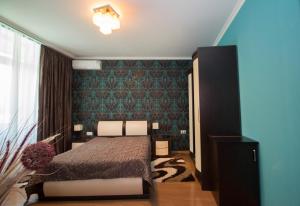 Un dormitorio con una cama y una pared verde. en Eden, en Tiflis