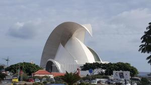 a building with a curved roof in a parking lot at Suite Wagner in Santa Cruz de Tenerife