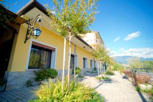a yellow building with a sidewalk next to a building at Miralago View in Revine Lago