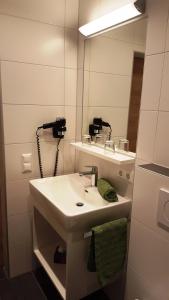 a bathroom with a sink and a mirror at Pension Jägerhof in Mallnitz